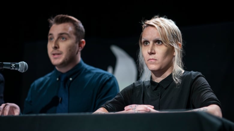 A woman with short blonde hair sits beside a man with short brown hair.