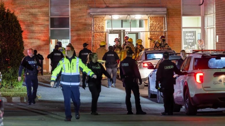 Police and firefighters at entrance to building