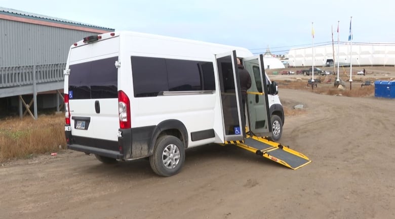 A van standing alone outside with a ramp. 