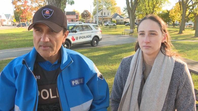 They stand in a park with a police cruiser behind them