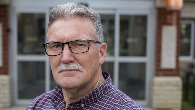 A man with a mustache and glasses. 