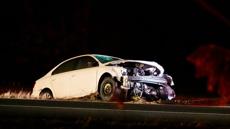 a white car involved in a collision. The entire front part is missing. 