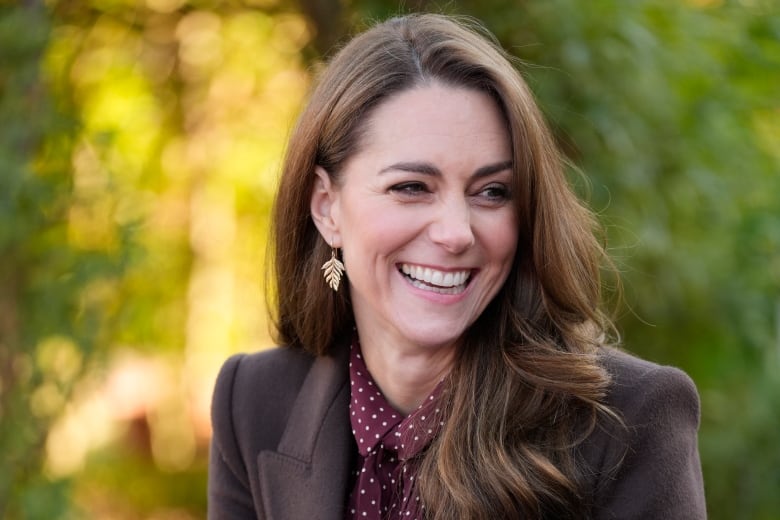 A closeup of a person smiling and looking to the right.