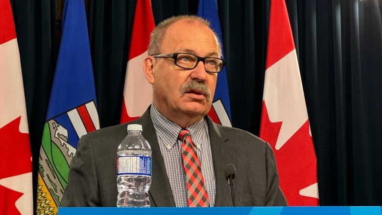 A man stands behind a podium