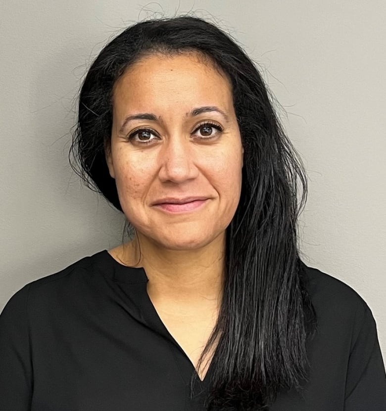 A woman in a black shirt with dark hair. 