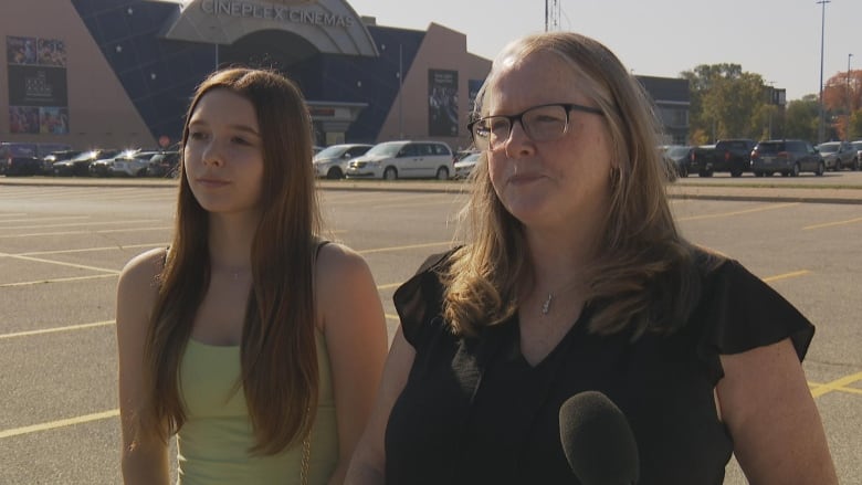 Photo of a woman and her daughter outside a cineplex