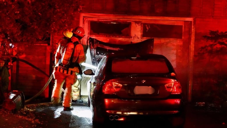 Firefighters and a torched car. 