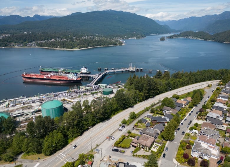 An aerial view of crude oil tankers at a dock in summer amid mountains of B.C.