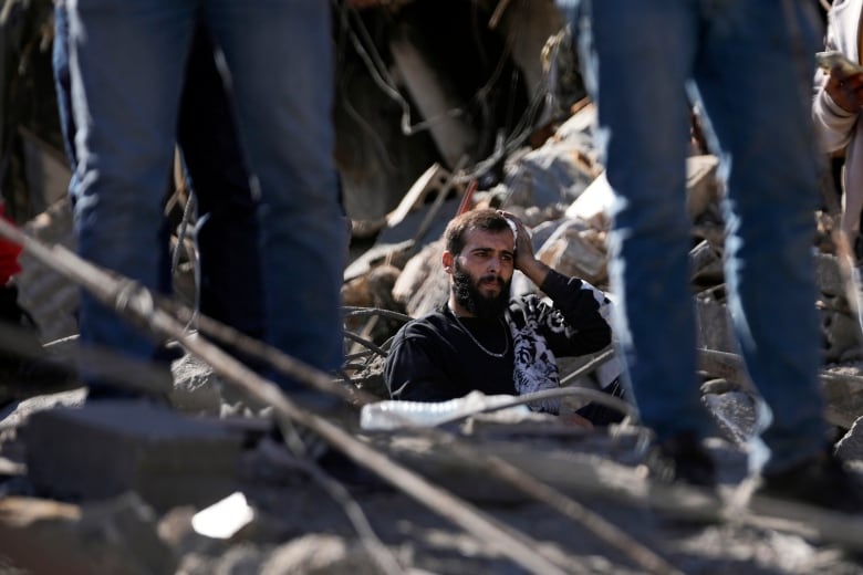 A man stands in rubble