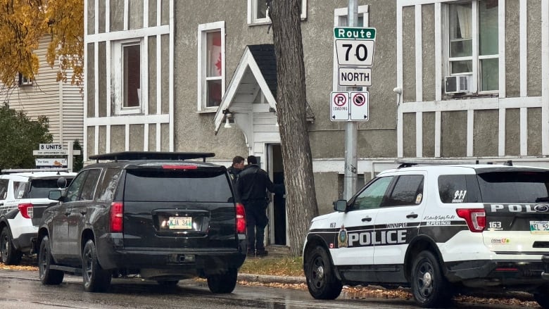 Police officers go into an apartment building.