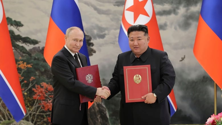 Russia's President Vladimir Putin and North Korean leader Kim Jong-un shake hands.