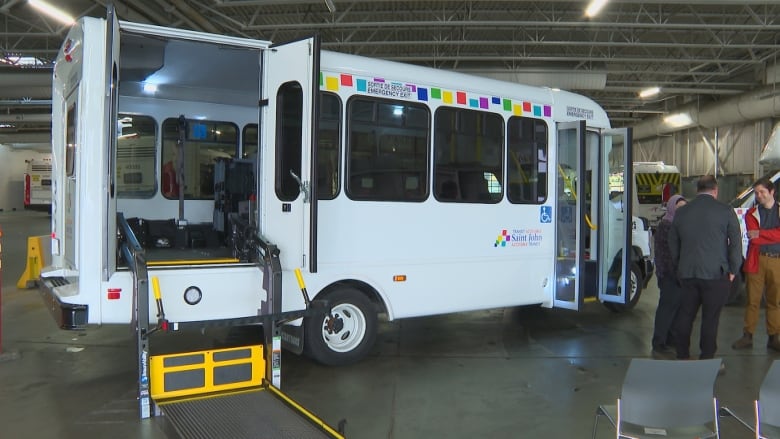 Paratransit bus pictured from the side with wheelchair lift down. 