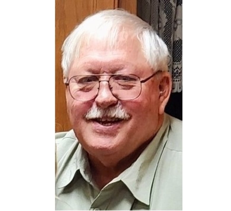 A smiling elderly man wearing glasses