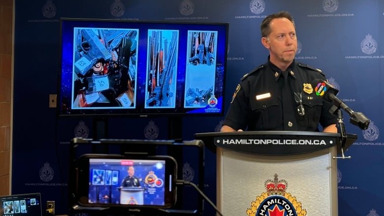 A man in police uniform speaks at a Hamilton Police Service podium.