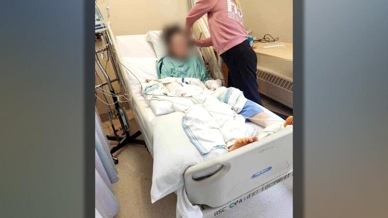 Meghan Smart's son is lying in a hospital bed with a nurse tending to his wounds.