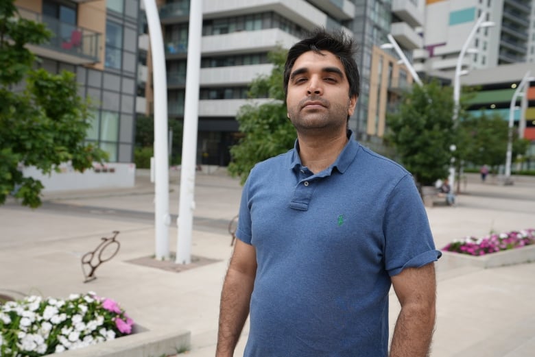 A man stands on a sidewalk.