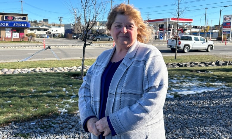 A woman smiles at the camera while standing along 16th Avenue in Calgary