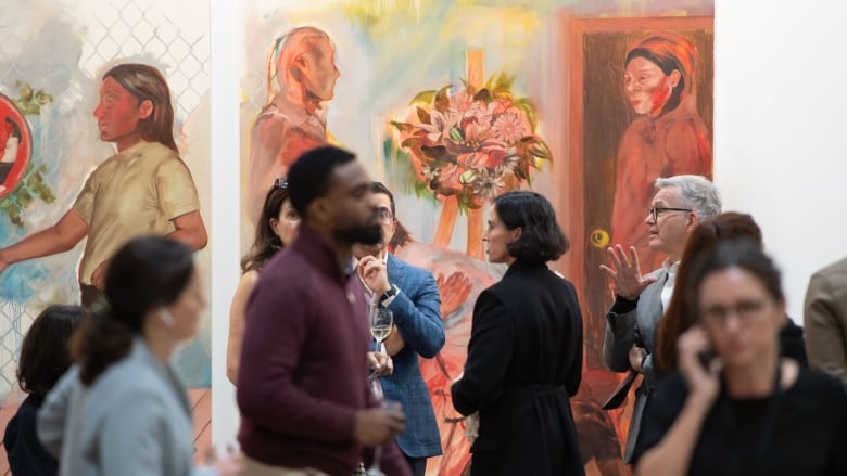 Crowd walks in front of a figurative painting of great size.