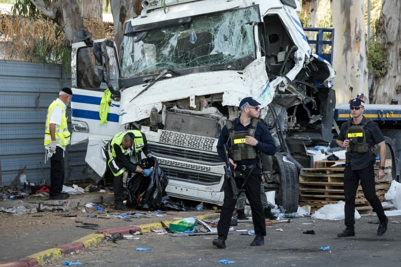 Israeli police and rescue services inspect the site where a truck driver rammed into a bus stop.