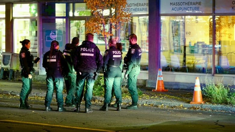 Police officers gathered on a street. 