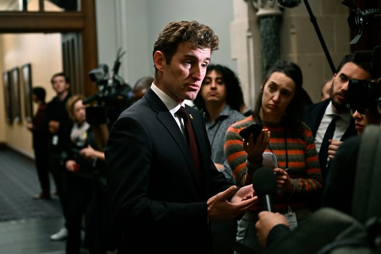 Liberal MP Yvan Baker speaks to reporters before a meeting of the Liberal caucus on Parliament Hill in Ottawa on Wednesday, Oct. 9, 2024. Baker is calling for a secret ballot vote on Trudeau's future.