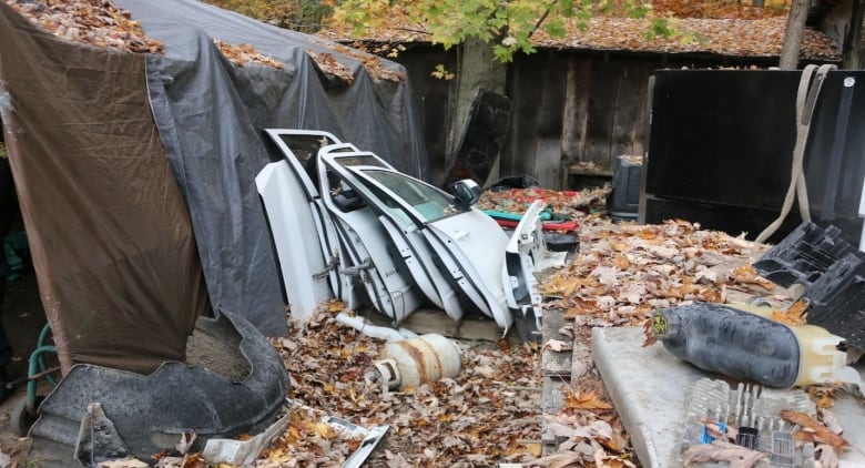 Several car doors and other car parts stacked against each other.