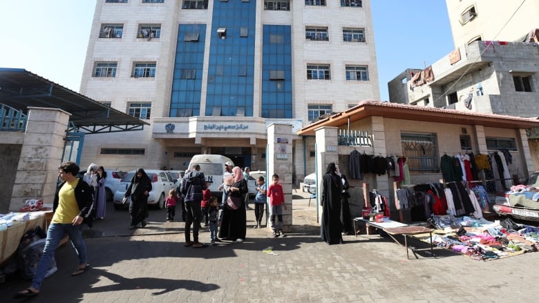 People walk outside a health centre.