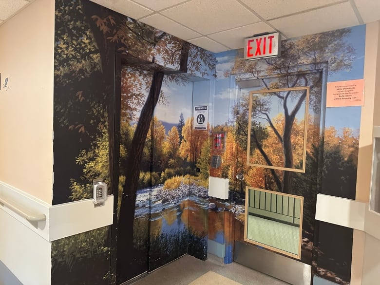 A picture of an elevator that is painted to look like it is a forest.