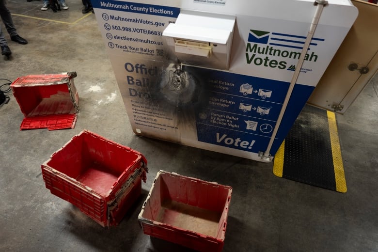 A fire-damaged ballot box is seen on display at a news conference in Portland, Ore.