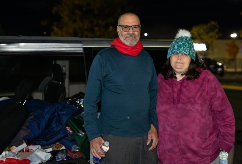 Two people in front of a van