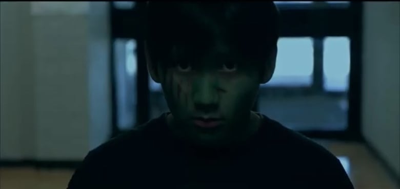 a photo of a young boy with zombie make up on.