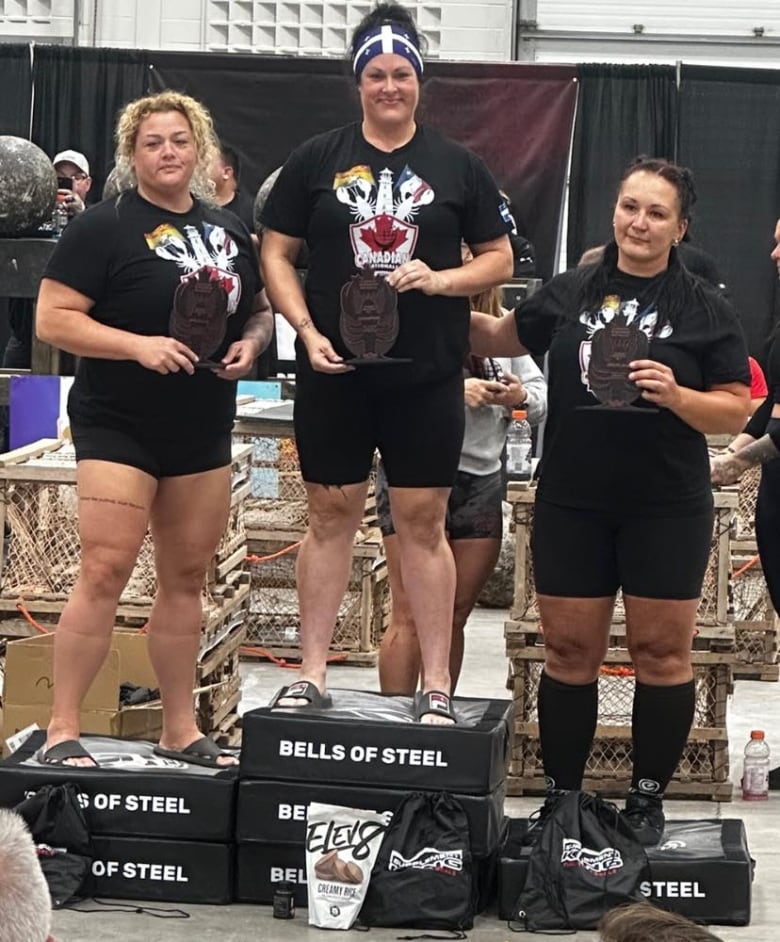 Three women standing on a podium.