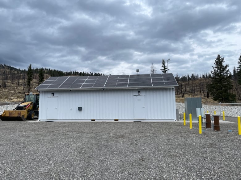 While building with solar panels in a fenced gravel parking lot