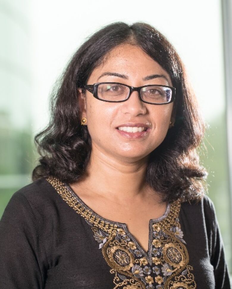 A girl in glasses smiles at camera