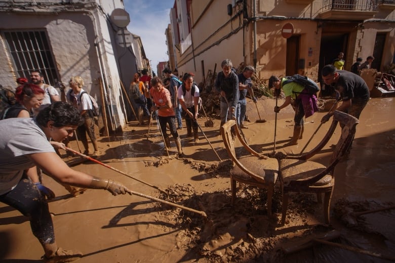 Residents and volunteers clean up an area affected by floods.