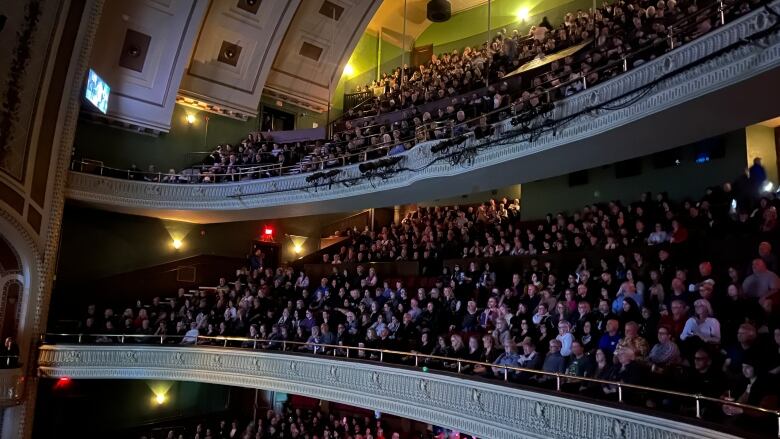 Crowds sitting on the balconies of a theatre