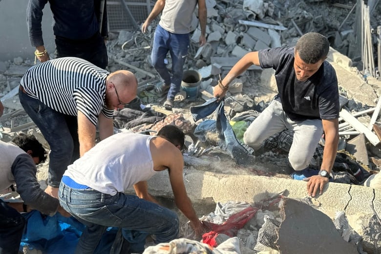 People digging up rubble.