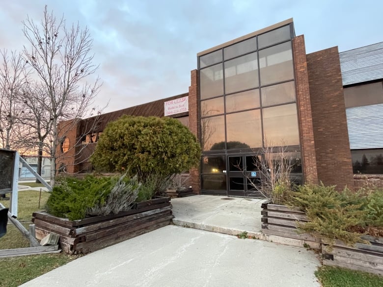 Brown brick two-storey building featuring an atrium-style lobby.  