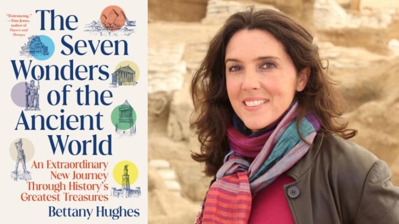 A white woman, with long brown hair is smiling into the camera. She is wearing a pink and purple scarf, dark pink sweater and brown leather jacket. Behind her are ancient ruins. To your left is the cover of her book, The Seven Wonders of the Ancient World. 