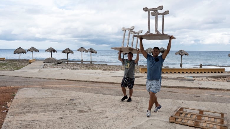 Furniture is carried away from a Havana restaurant, ahead of the expected arrival of Tropical Storm Rafael.