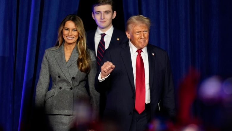 Pumping his fist, Donald Trump enters the stage with his wife Melania and son, Barron, before his speech at his election night watch party in front of media and supporters.