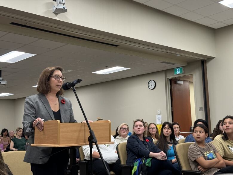 A woman speaks at a podium. 