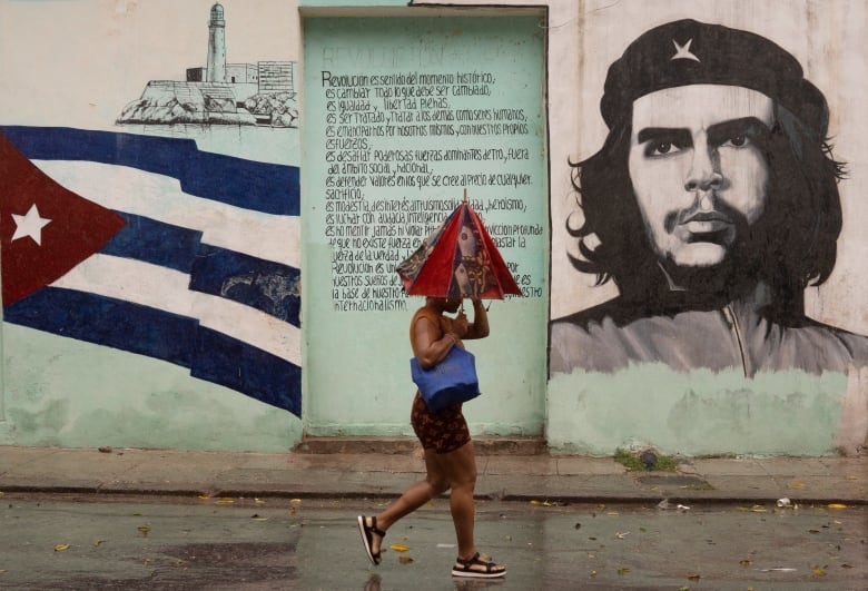 A woman i seen walking on the street as Hurricane Rafael passes by Havana, Cuba.