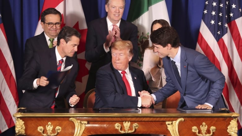  Donald Trump, center, shakes hands with Canada's Prime Minister Justin Trudeau as Mexico's President Enrique Pena Nieto looks on after they signed a new United States-Mexico-Canada Agreement