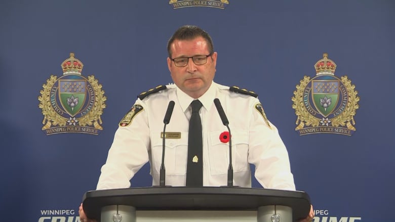 A man in a uniform stands at a podium.