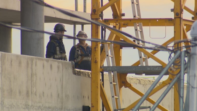 people in a building under construction next to yellow scaffolding.