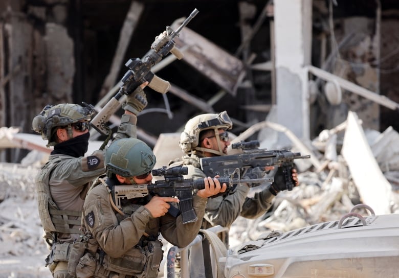 Israeli soldiers hold weapons, amid the ongoing ground operation of the Israeli army against Palestinian Islamist group Hamas, in the Gaza Strip, September 13, 2024. 