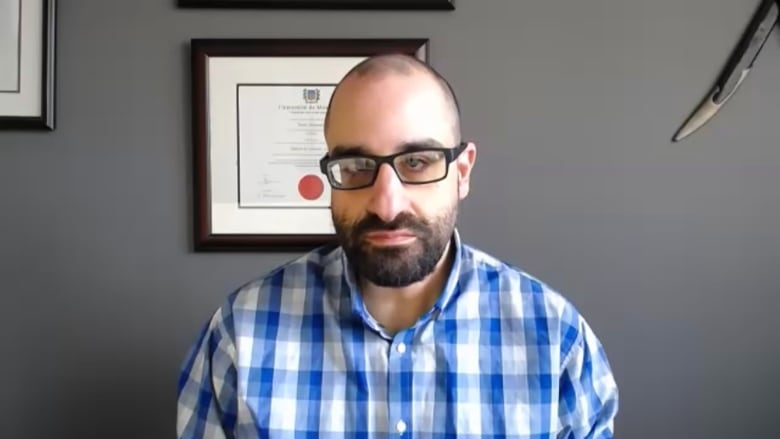 David sits in his office. 