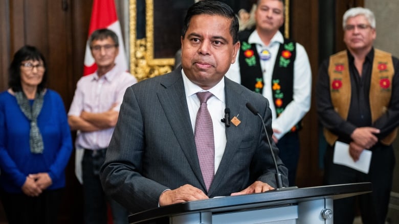 A man stands at a lectern.