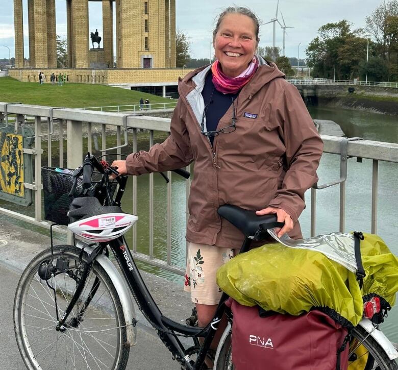 A woman with a bike smiles at the camera 